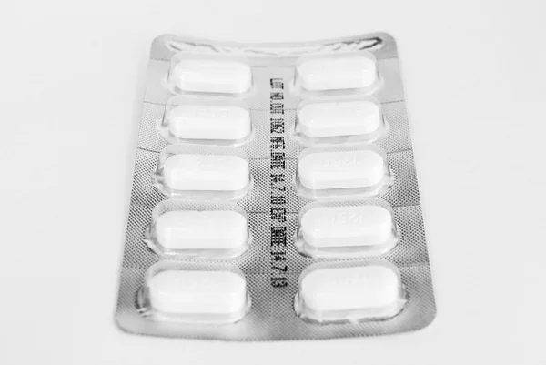 Fehér háttér előtt fehér gyógyszer tabletták csomag — Stock Fotó