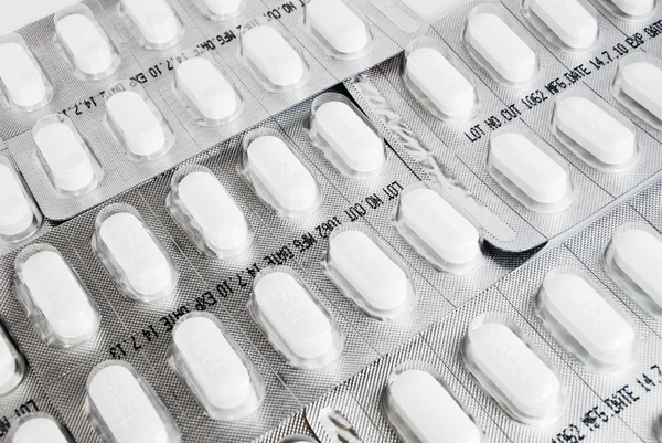 Förpackning med vita medicin piller bakgrund — Stockfoto