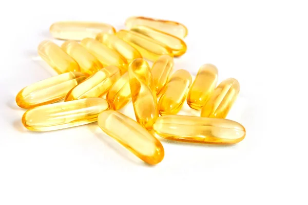 Pile of shiny yellow capsule vitamin isolated — Stock Photo, Image