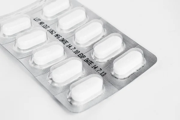 Packung weißer Medikamententabletten auf weißem Hintergrund — Stockfoto