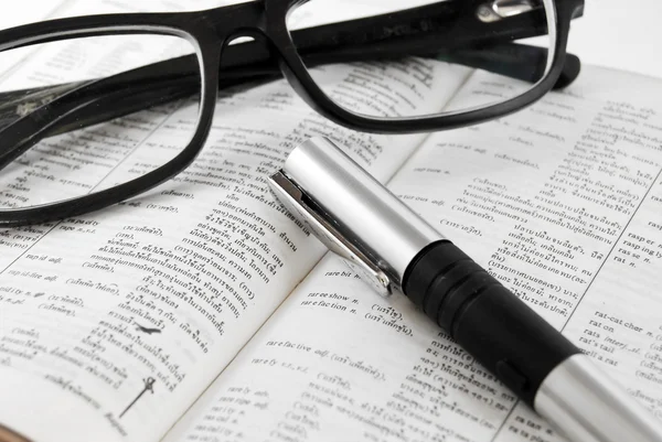 Closeup slovník a brýle s perem — Stock fotografie