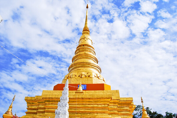 Golden Pagoda in Buddha temple on the beautiful cloudy sky , Asia , Thailand