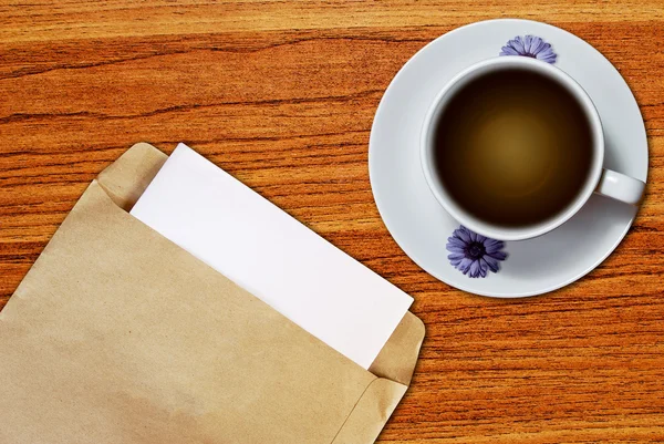 White cup of coffee and brown envelope — Stock Photo, Image