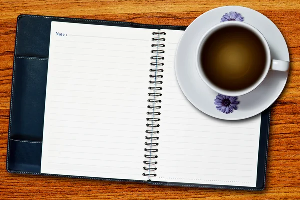 白杯咖啡和木桌背景上的空白页笔记本 — 图库照片