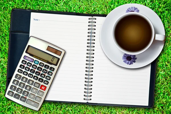 White Cup Coffee Blank Notebook Calculator Fresh Green Grass Background — Stock Photo, Image