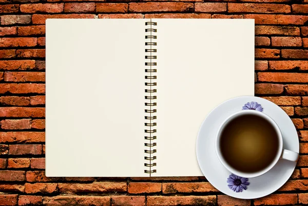 白杯咖啡和砖背景墙上的空白页笔记本 — 图库照片