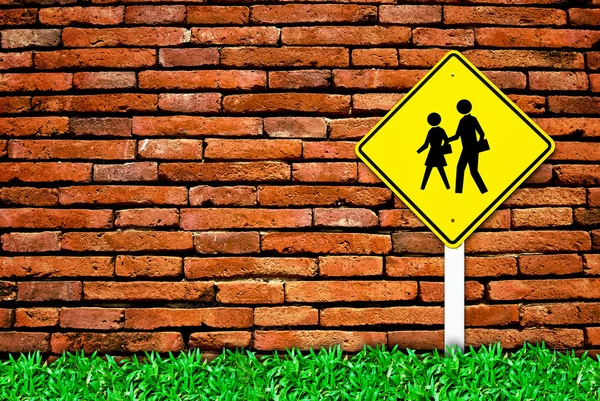 学校警告交通符号标志上砖壁背景和草地场 — 图库照片