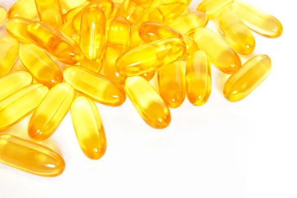 Shiny yellow fish oil capsule pills closeup — Stock Photo, Image