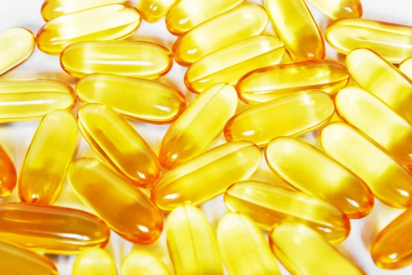 Glanzende gele vissen olie capsule pillen close-up — Stockfoto