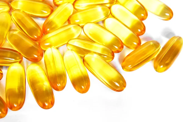 Shiny yellow fish oil capsule pills closeup — Stock Photo, Image
