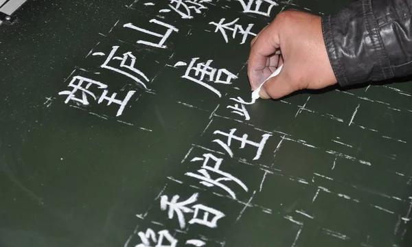 Um professor de escola rural está escrevendo quadro preto — Fotografia de Stock