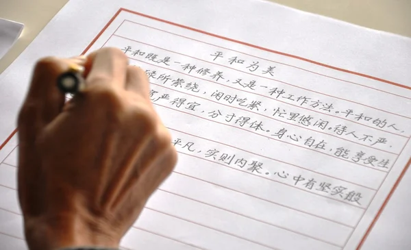 En gammal man skriver kinesiska tecken — Stockfoto