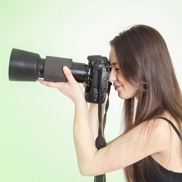 En ung kvinnlig fotograf med en professionell kamera — Stockfoto