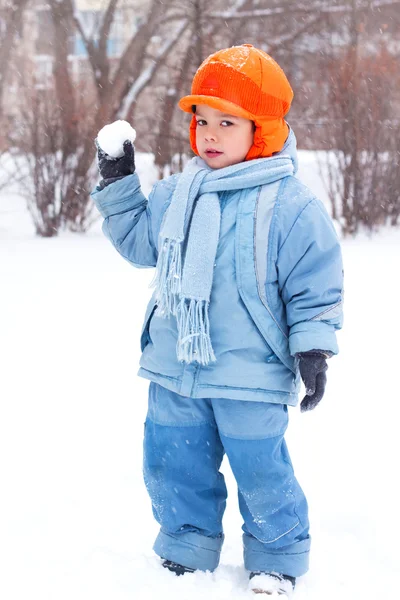 Little boy playing snowballs; snowman sculpts; digs snow; — Stock Photo, Image
