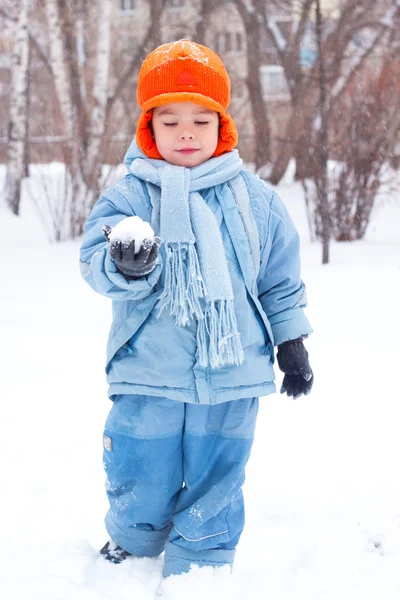 Niño jugando bolas de nieve; muñeco de nieve esculpe; cava nieve ; —  Fotos de Stock