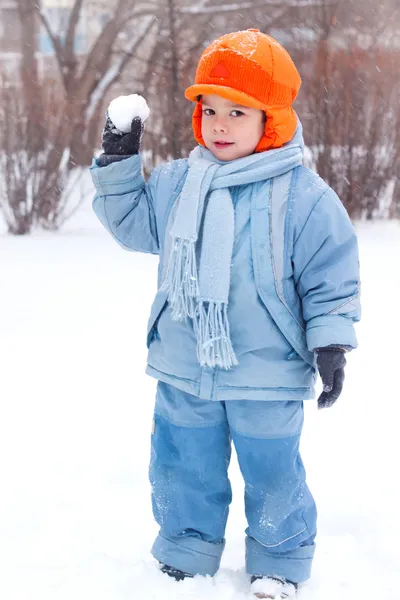 Malý chlapec hraje sněhové koule; sněhulák sculpts; podnájem sníh; Stock Fotografie