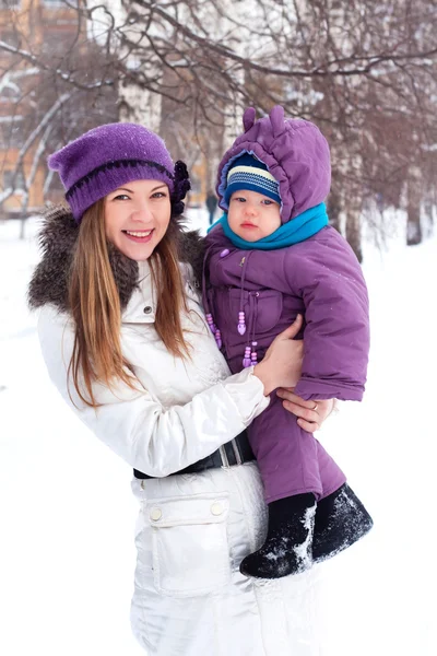 Μητέρα που κρατάει ένα μωρό, χιόνι, χειμερινό πάρκο, με τα πόδια — Φωτογραφία Αρχείου