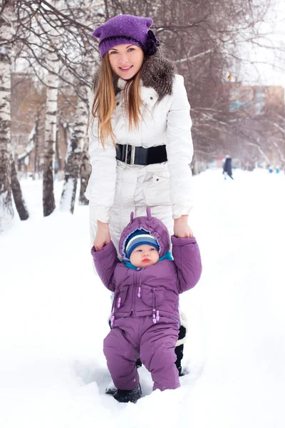 Μητέρα που κρατάει ένα μωρό, χιόνι, χειμερινό πάρκο, με τα πόδια — Φωτογραφία Αρχείου