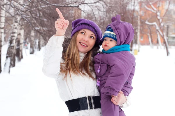 Mother holding a baby, snow, winter park, walk — Stock Photo, Image