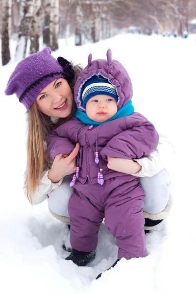 Matka drží dítě, sníh, winter park, chůze Stock Fotografie
