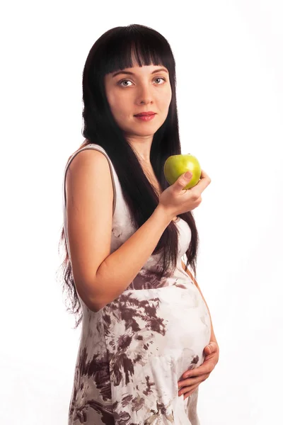 Piękna, młoda dziewczyna w ciąży jest jedzenie jabłka. — Zdjęcie stockowe