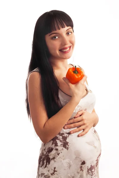 Piękna, młoda dziewczyna w ciąży jest jedzenie pieprz. — Zdjęcie stockowe