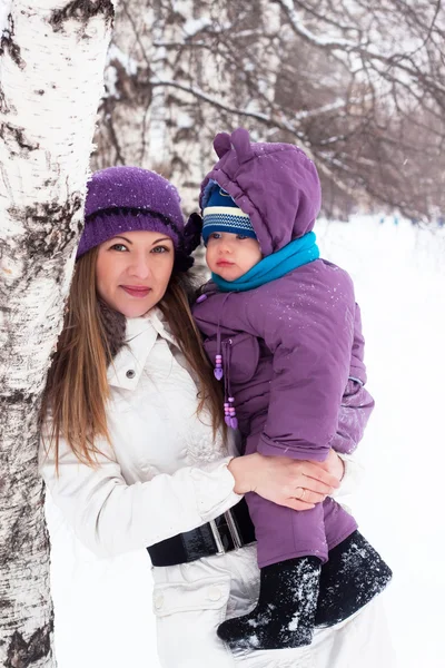 Día de invierno una familia feliz, mamá y el bebé, nieve, parque, caminar —  Fotos de Stock