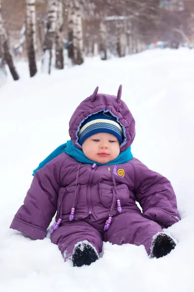 Ένα μικρό αγόρι, μωρό κάθεται στο χιόνι, χιονόμπαλα — Φωτογραφία Αρχείου