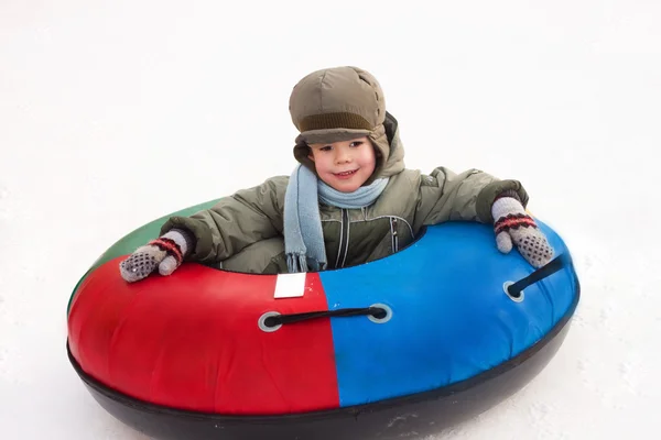 Winter walk; boy rides a Snowtubing; sleds; hill; playing snowba — Stock Photo, Image