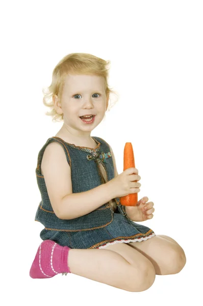 Маленькая девочка с морковкой — стоковое фото