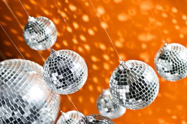 Mirrored disco balls with light spots over background clipart