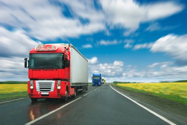 Trucks at country road at sunny day clipart