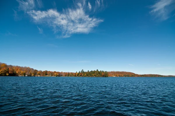 Canadees meer met herfstkleuren en blauwe lucht — Stockfoto