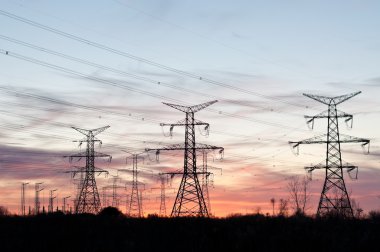 Electrical Transmission Towers (Electricity Pylons) at Sunset clipart