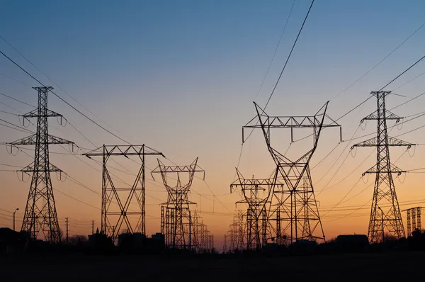 Torres de transmissão elétrica (postes de eletricidade) ao pôr do sol — Fotografia de Stock