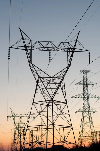 Tours de transmission électrique (pylônes d'électricité) au coucher du soleil Photo De Stock