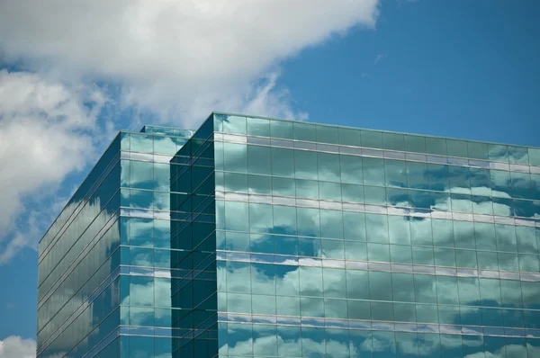 Torre dell'ufficio che riflette cielo blu e nuvole — Foto Stock