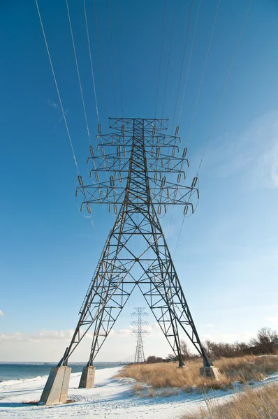 Tour de transmission électrique (cylindre d'électricité) à côté d'un lac Images De Stock Libres De Droits