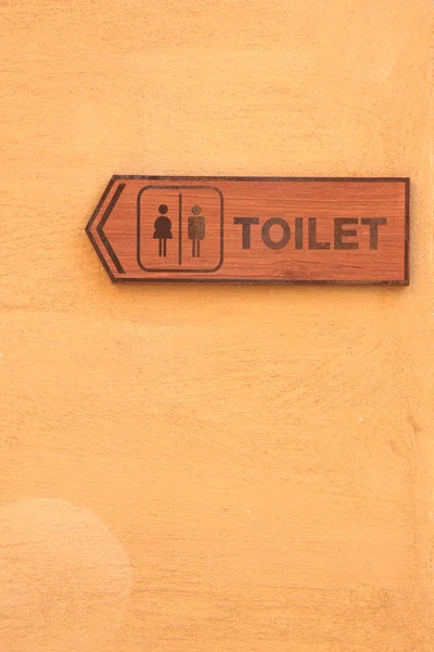 Etiqueta de madeira de toalete na parede laranja . — Fotografia de Stock