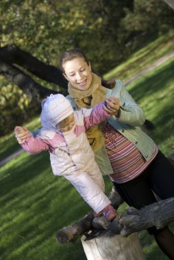 Mother and the daughter play the nature clipart