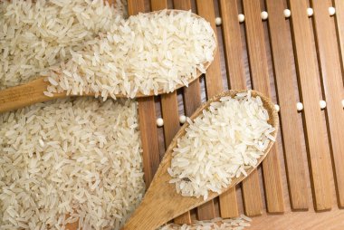 rice grits in wooden spoons on the table clipart