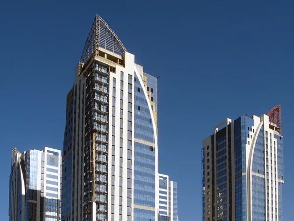 stock image New towerlike buildings against a background of blue sky