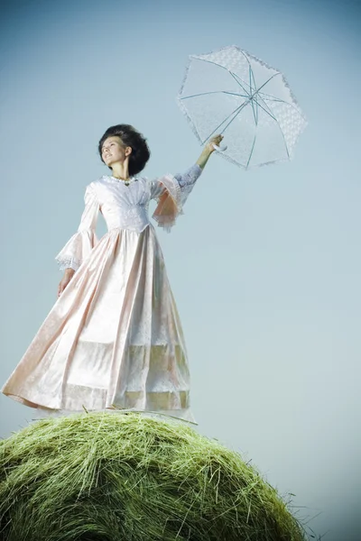 Vacker kvinna i vintage klänning stående på höstacken — Stockfoto