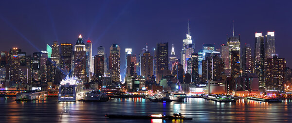 Modern City night scene. New York City Manhattan skyline panorama at night over Hudson River with refelctions viewed from New Jersey