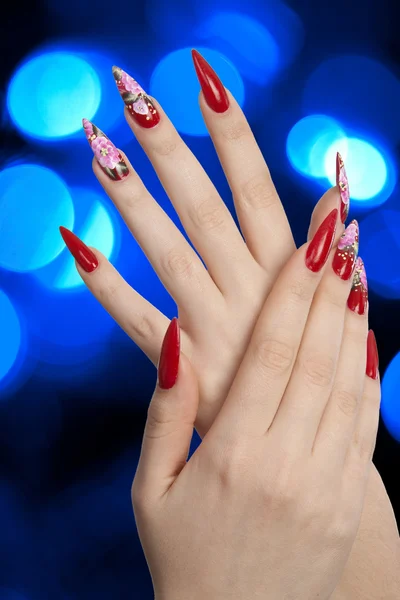 Beautiful red nails and blue lights — Stock Photo, Image