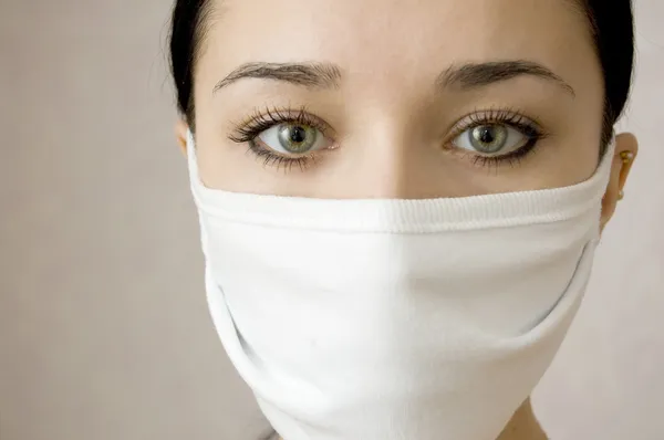 Gezicht van mooie vrouwen in een medische masker — Stockfoto