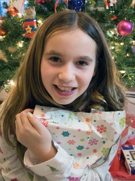プレゼントを開けるクリスマスの女の子 ストック写真