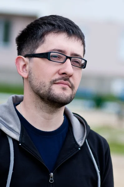 Gözlüklü genç sakallı bir adam portresi