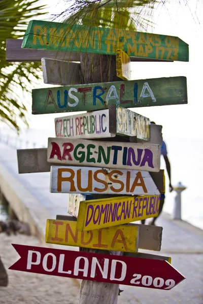 Zabawne drogowskaz wskazujące kierunek krajów z grand cayman — Zdjęcie stockowe