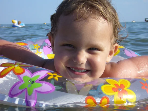 Yakın çekimler denizde şişme bir disk üzerinde mutlu bebek. — Stok fotoğraf